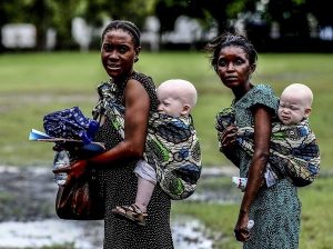 Deux femmes portant leurs enfants albinos, en mai 2014 à Dar es Salaam, ancienne capitale tanzanienne. Selon des groupes de défense des albinos, il y aurait environ 100 000 albinos en Tanzanie, sur une population totale de 48 millions d’habitants. / BUNYAMIN AYGUN / AFP